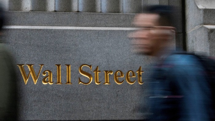 Blurred image of people walking past the New York Stock Exchange